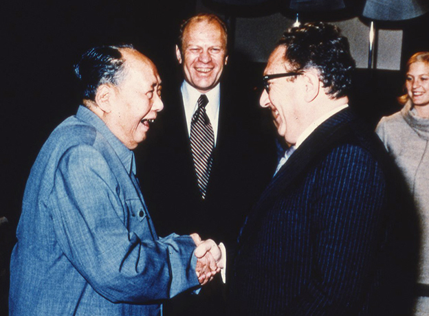 Президент США Джеральд Форд наблюдает, как Генри Киссинджер пожимает руку Мао во время их визита в Китай, 2 декабря 1975 г.